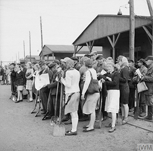  Workers, amongst whom are many women, leave the camp. All are recruited from surrounding villages. (Imperial War Museum)